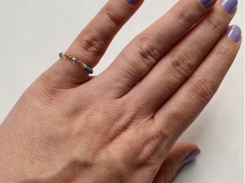 Hand wearing a bead ring