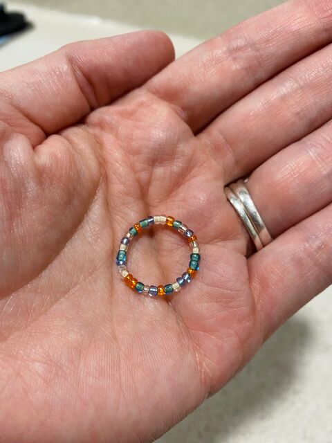 Hand holding a bead ring hand wea